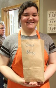 Volunteer Allie Rooney, a sophomore at Peoria Notre Dame High School, holds one of the lunch bags assuring Sophia's Kitchen patrons that God loves them. (The Catholic Post/Jennifer Willems)