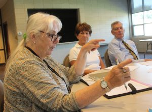 Kate King of St. Pius X Parish offers a suggestion during a discussion about the Congolese refugee family the parish is helping to resettle. Looking on are core committee members Lili and Clarence Darrow. (The Catholic Post/Jennifer Willems) 