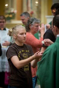 Rachel Carroll from Pontiac receives Communion at the Youth Rally Mass in St. Mary's Cathedral. (For The Catholic Post/Daryl Wilson)
