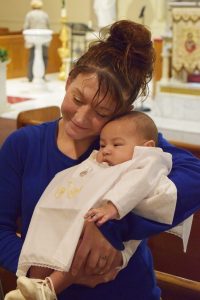 Tiffany cradles newly baptized Jayke. (The Catholic Post/Tom Dermody)