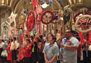 Catholics hold up "parols," or Christmas lanterns, for blessing during a “Simbang Gabi” Mass in Seattle. The novena of pre-Christmas Masses, popular among Filipinos, will be hosted by nine Peoria-area churches Dec. 14-22. (CNS file photo)