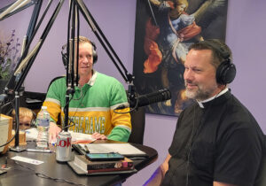 Msgr. Jason Gray, executive director of the Archbishop Fulton Sheen Foundation, discusses the sainthood cause of Archbishop Sheen with Catholic Spirit Radio host Royce Hood (center) on Oct. 25 at the network’s studio in Normal. (Provided photo)