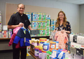 Msgr. James Kruse, pastor of St. Louis Parish in Princeton, is pictured with Jessica Murphy, director of the parish’s new Magi Baby Chest, and just some of the baby and toddler supplies already donated or purchased for the outreach located in the St. Louis Catechetical Center. It will open for the first time on the morning of Oct. 1, the start of Respect Life Month, and continue on the first Saturday of every month. (The Catholic Post/Tom Dermody)