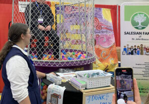 Bishop Louis Tylka takes a turn in a dunk tank at the National Catholic Youth Conference in Indianapolis last weekend. He promised those who knocked him off the perch that "they didn’t have to go to confession for dunking the bishop.” (Provided photo/ Carla Wizieck)