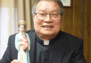 Father Vien Van Do holds a statue of Our Lady of Lavang given to him by the Altar and Rosary Society when he served at St. John the Baptist Parish in Bradford. He says God saved his life through the Blessed Mother’s protection on several occasions. “I carry her in my heart,” he adds. (The Catholic Post/Tom Dermody)
