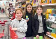 Jordan Catholic fifth graders (from left) Hudson Kerr, Svea Hancks, and QuinEvelyn Allison shop in support of families in need at Christmas.